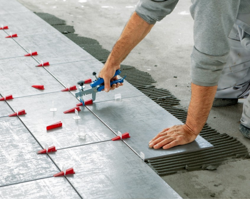 Man installing tile | Shans Carpets And Fine Flooring Inc